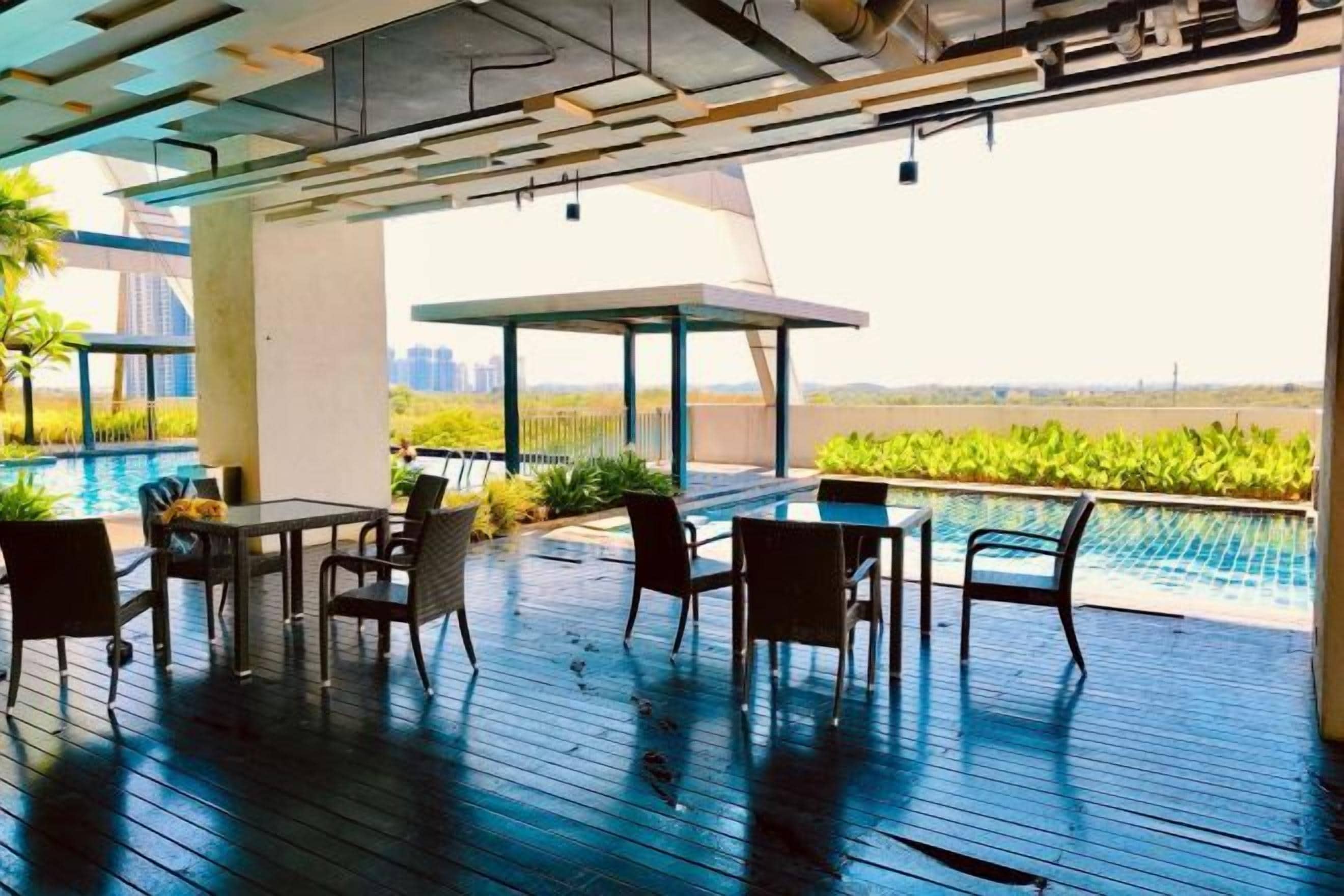 A rooftop pool area with outdoor seating and a view of the city skyline.