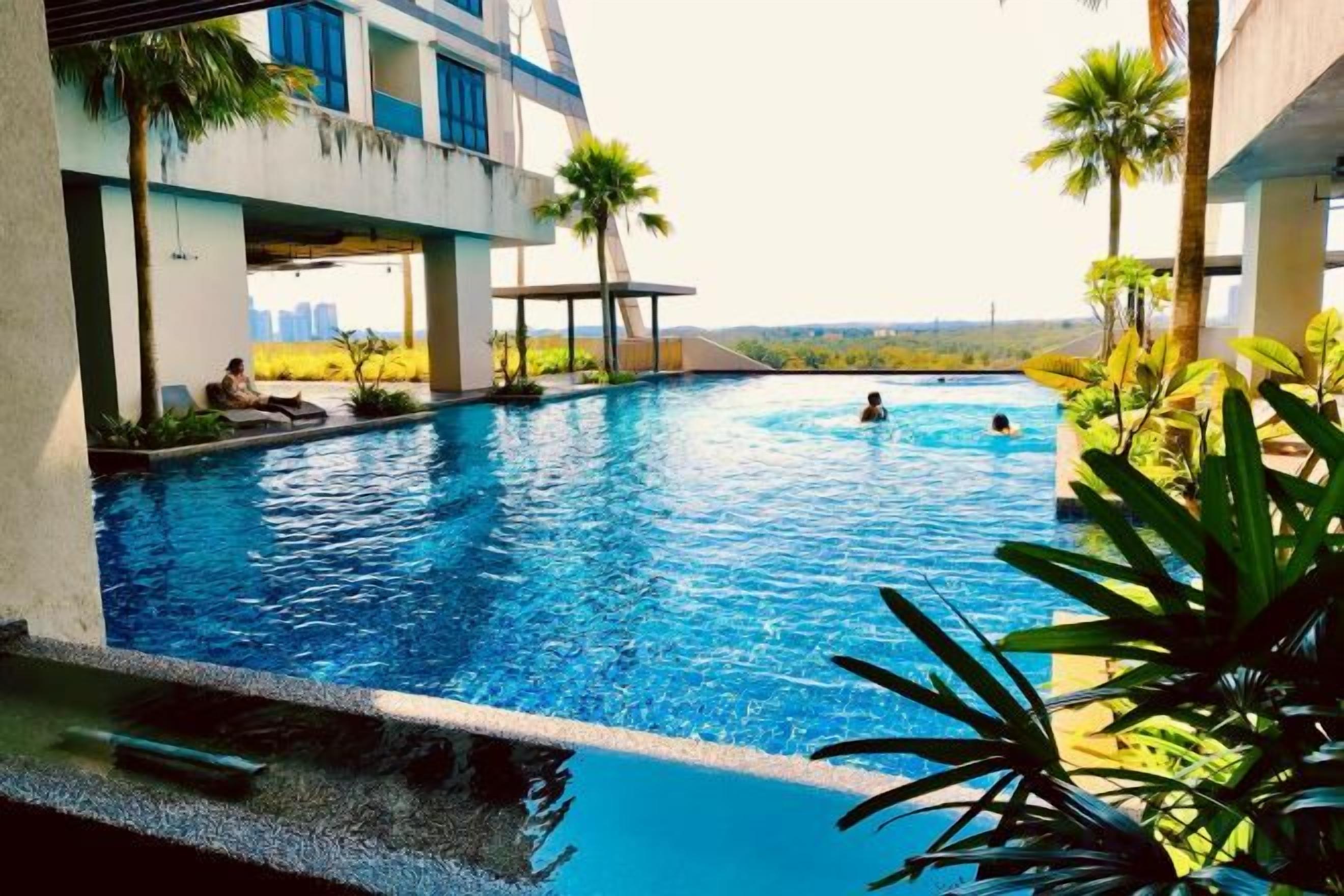 A swimming pool with a view of the city skyline, surrounded by palm trees and modern architecture.