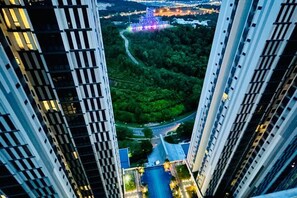 A high-rise building with a view of a river and greenery below. - Ramada medini Apartment (Iskandar Puteri)
