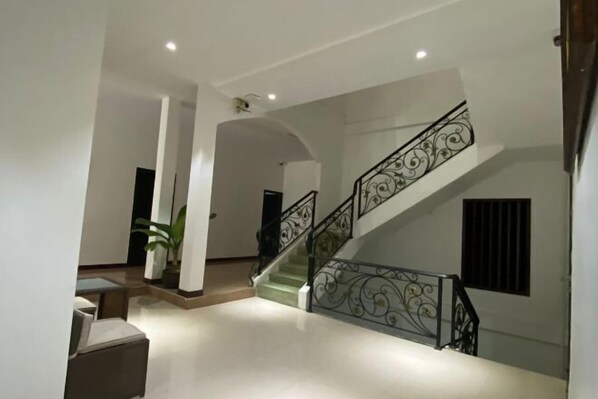 A spacious interior with a staircase, white walls, and a minimalist design. - Subinh Hotel (Pakse)