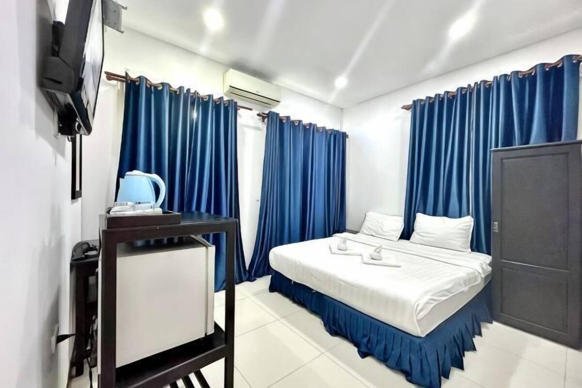 Una habitación de hotel con cama, escritorio con lámpara y armario.