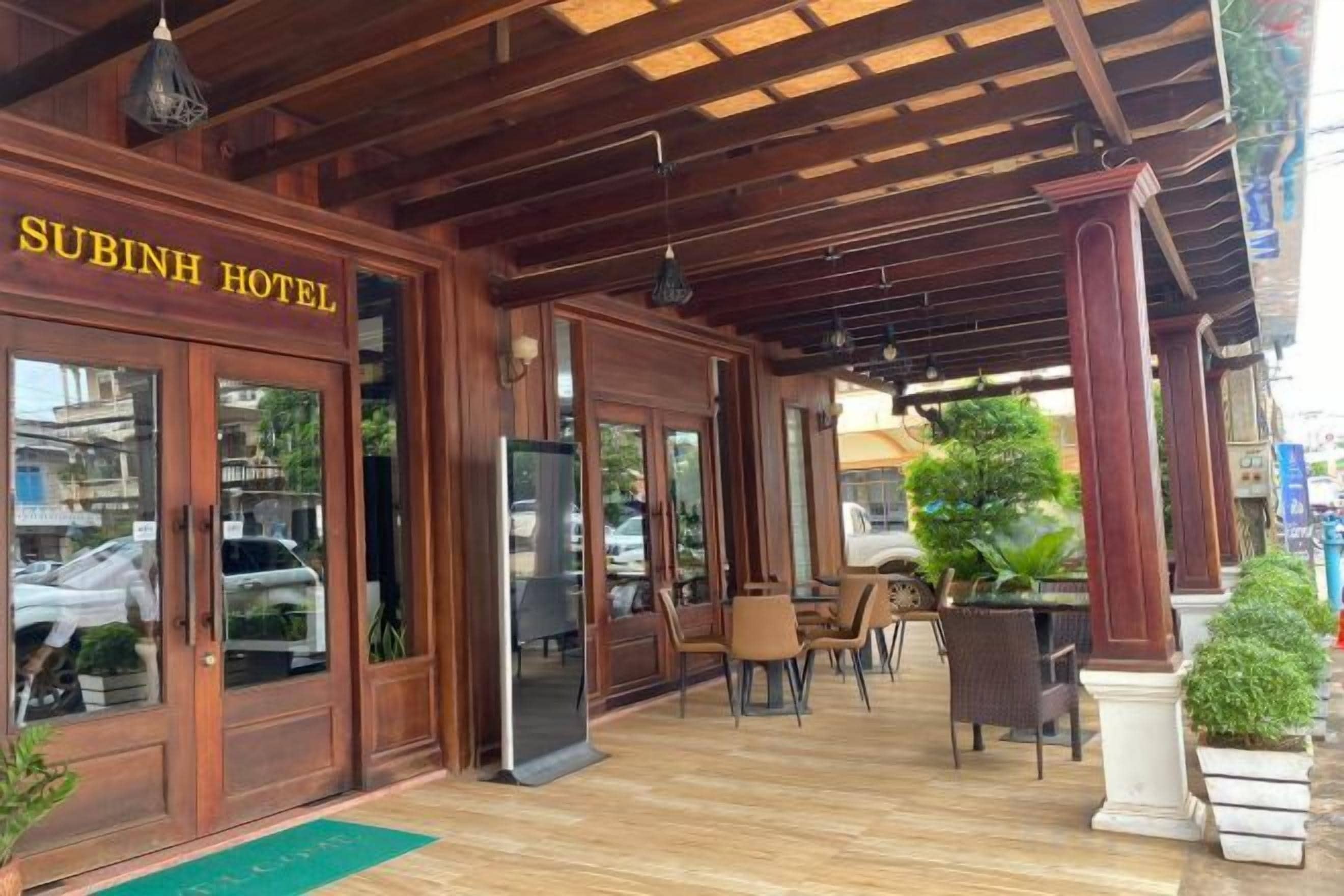 A wooden exterior of Subinh Hotel with a covered outdoor seating area.