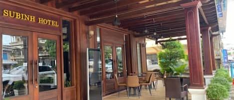 A wooden exterior of Subinh Hotel with a covered outdoor seating area.