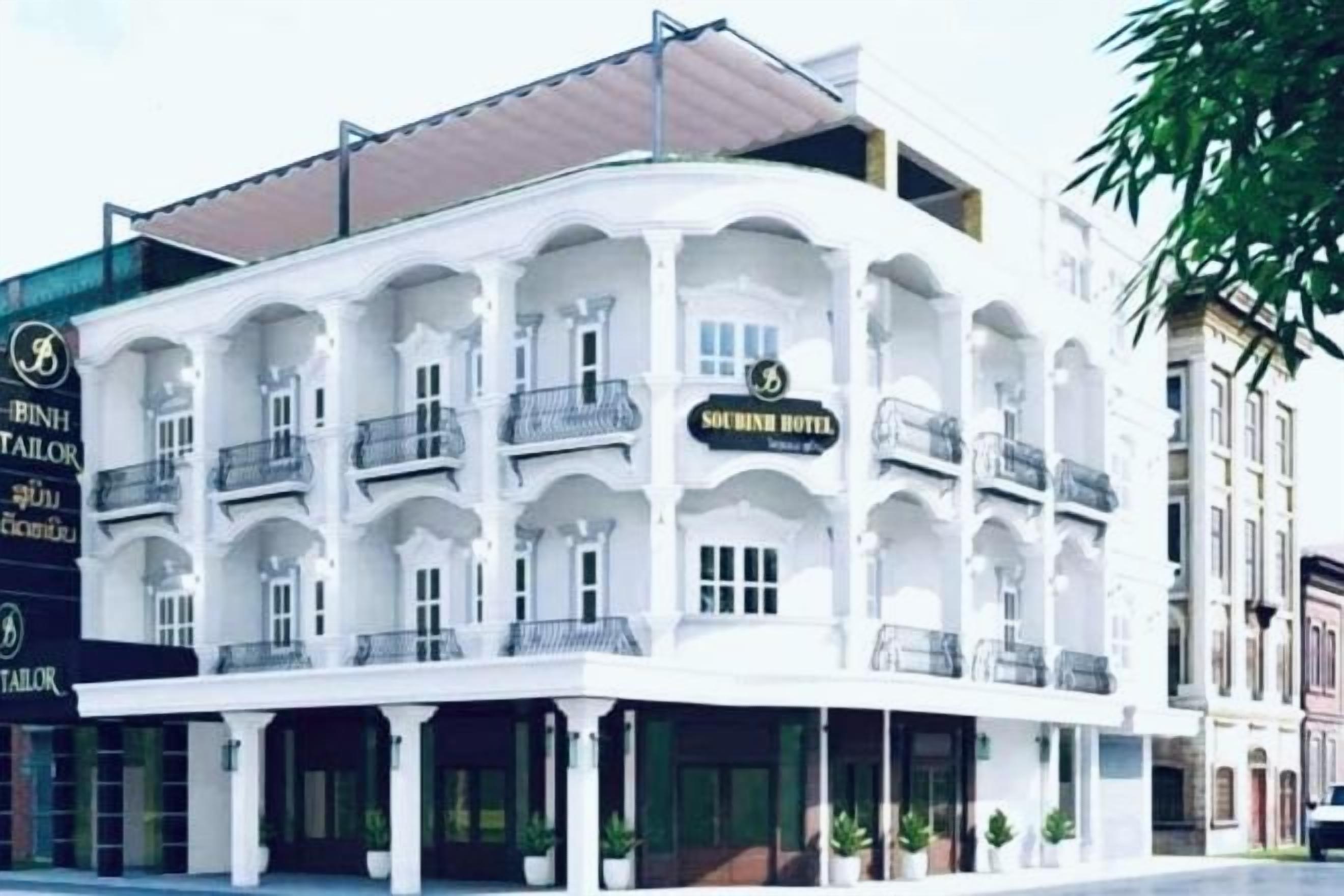 Un edifici de diverses plantes amb façana corbada, balcons i un rètol que indica que és un hotel.