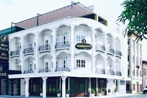 A multi-story building with a curved facade, balconies, and a sign indicating it is a hotel. - Subinh Hotel (Pakse)