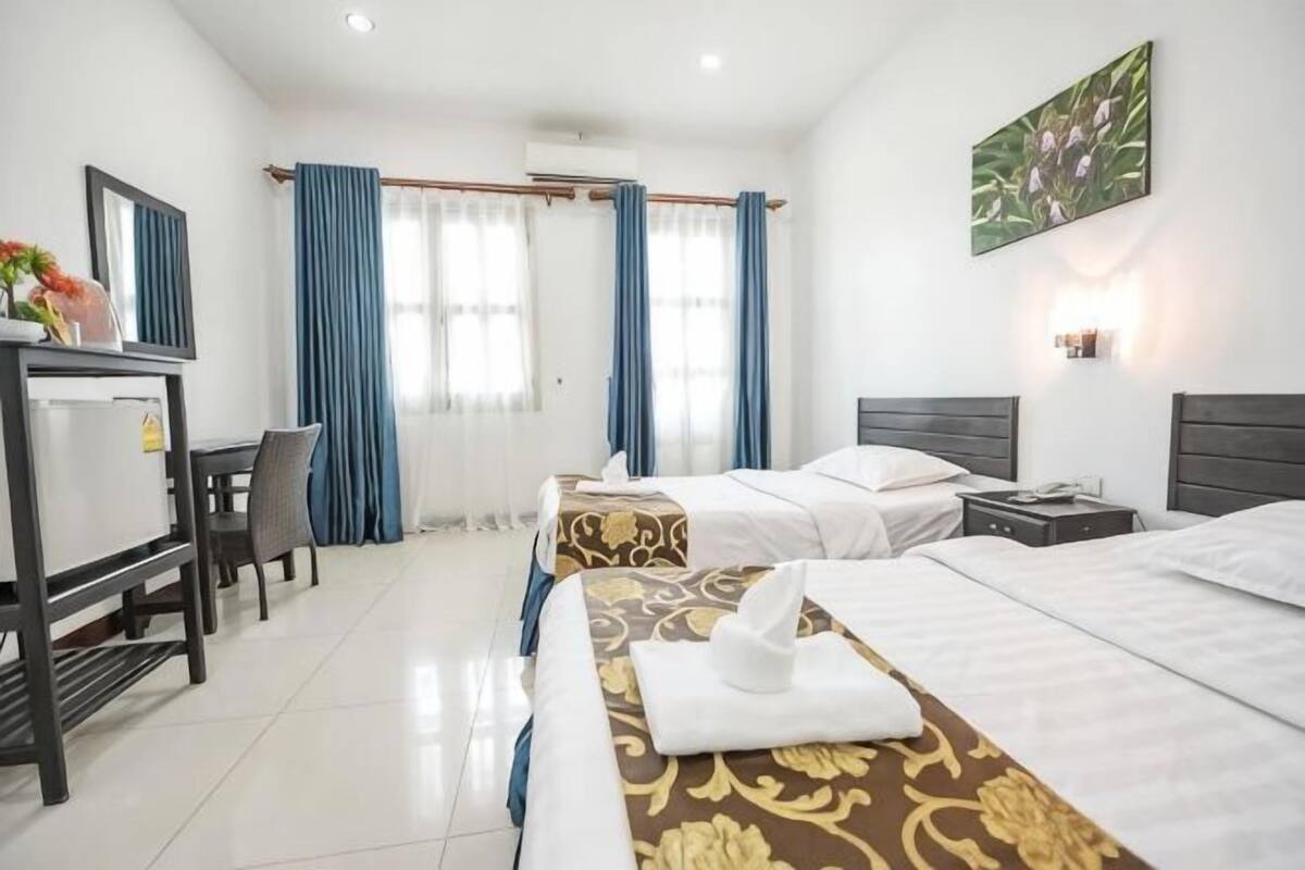 Una habitación de hotel con dos camas, un escritorio y una silla.