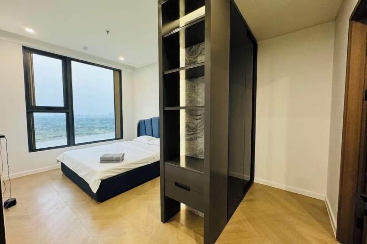 Una camera da letto con un letto, un'ampia finestra e un armadio a muro.