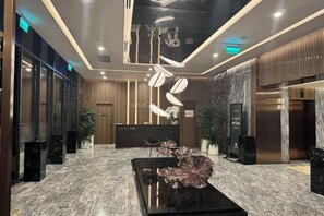 Una zona de recepción moderna con suelo de mármol, un mostrador de recepción y una barra de atención al cliente.