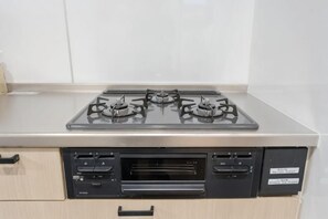 A kitchen with a stainless steel stove, a microwave, and a built-in oven. - Room 201 · Itabashi Minamicho · Diamond · Yu (Tokyo)