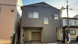 Un bâtiment à deux étages, doté d’un toit plat, d’une entrée principale avec une porte et d’un petit porche.
