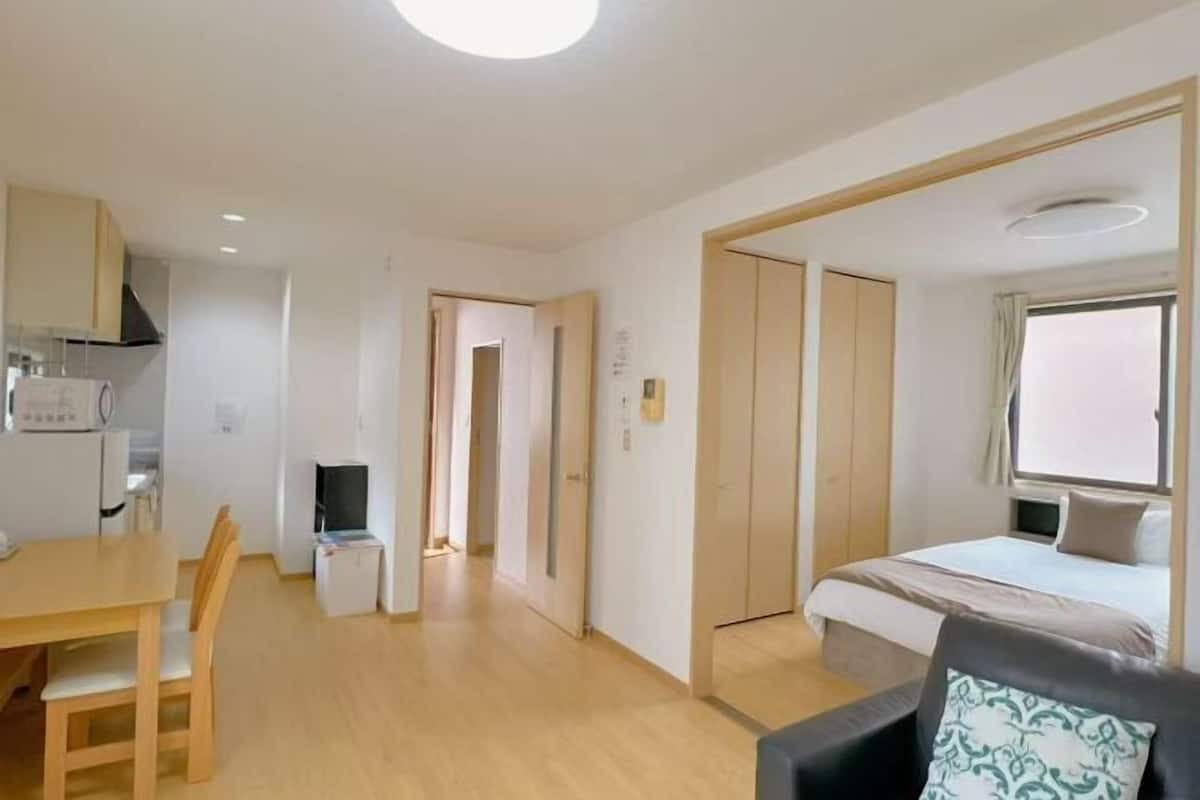 Une chambre d’hôtel équipée d’un lit, d’un bureau, d’une chaise, d’une télévision et d’une kitchenette.