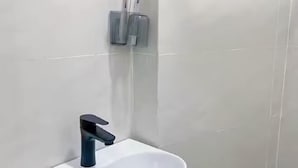 A bathroom with a white sink, a black faucet, and a soap dispenser mounted on the wall. - Small Private house in Bui Vien Walking Street (Ho Chi Minh City)