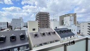 Un paysage urbain comprenant de nombreux bâtiments, dont un grand bâtiment blanc doté d’un toit plat et plusieurs structures plus petites avec des toits inclinés.