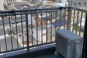 A balcony with a metal railing overlooking a residential area. - LuckyHouse yorokobiya 901 (Osaka)
