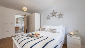 Une chambre à coucher avec un lit, des tables de chevet, une commode et un miroir.