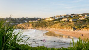 Une ville côtière dotée d’une plage de sable, de zones verdoyantes et de bâtiments qui se dressent à l’arrière-plan.