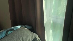 Una habitación con cama, cortinas y ventana.