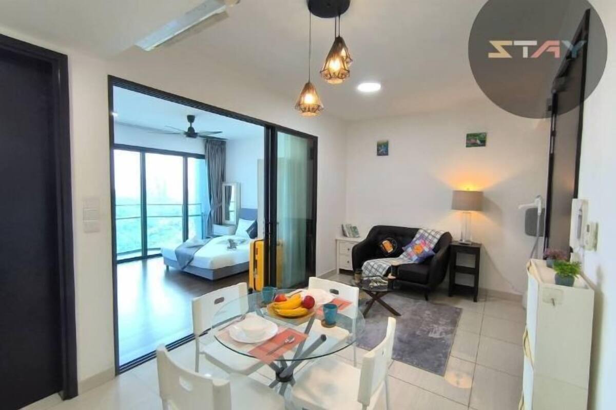 A modern living room with a glass dining table, a sofa, and a TV.