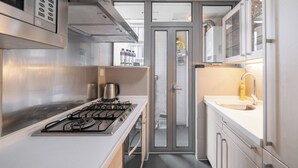 Una cocina moderna con electrodomésticos de acero inoxidable, estufa a gas y un lavamanos.