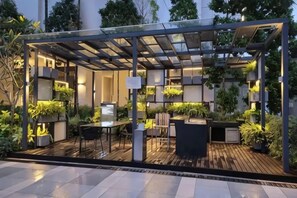 An outdoor patio area with a pergola, seating, and potted plants. - Grand Medini Homestay ByStay (Iskandar Puteri)