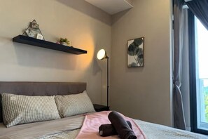 A bedroom with a bed, pillows, a bedside lamp, a window, and a wall-mounted shelf. - Grand Medini Homestay ByStay (Iskandar Puteri)