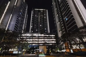 A high-rise building with multiple floors, large windows, and a central entrance area. - Grand Medini Homestay ByStay (Iskandar Puteri)