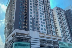 Un edificio de gran altura con varios pisos, ventanas amplias y un diseño arquitectónico moderno.