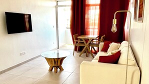 Un salon moderne comprenant un canapé, une table basse et un coin repas avec une table et des chaises.