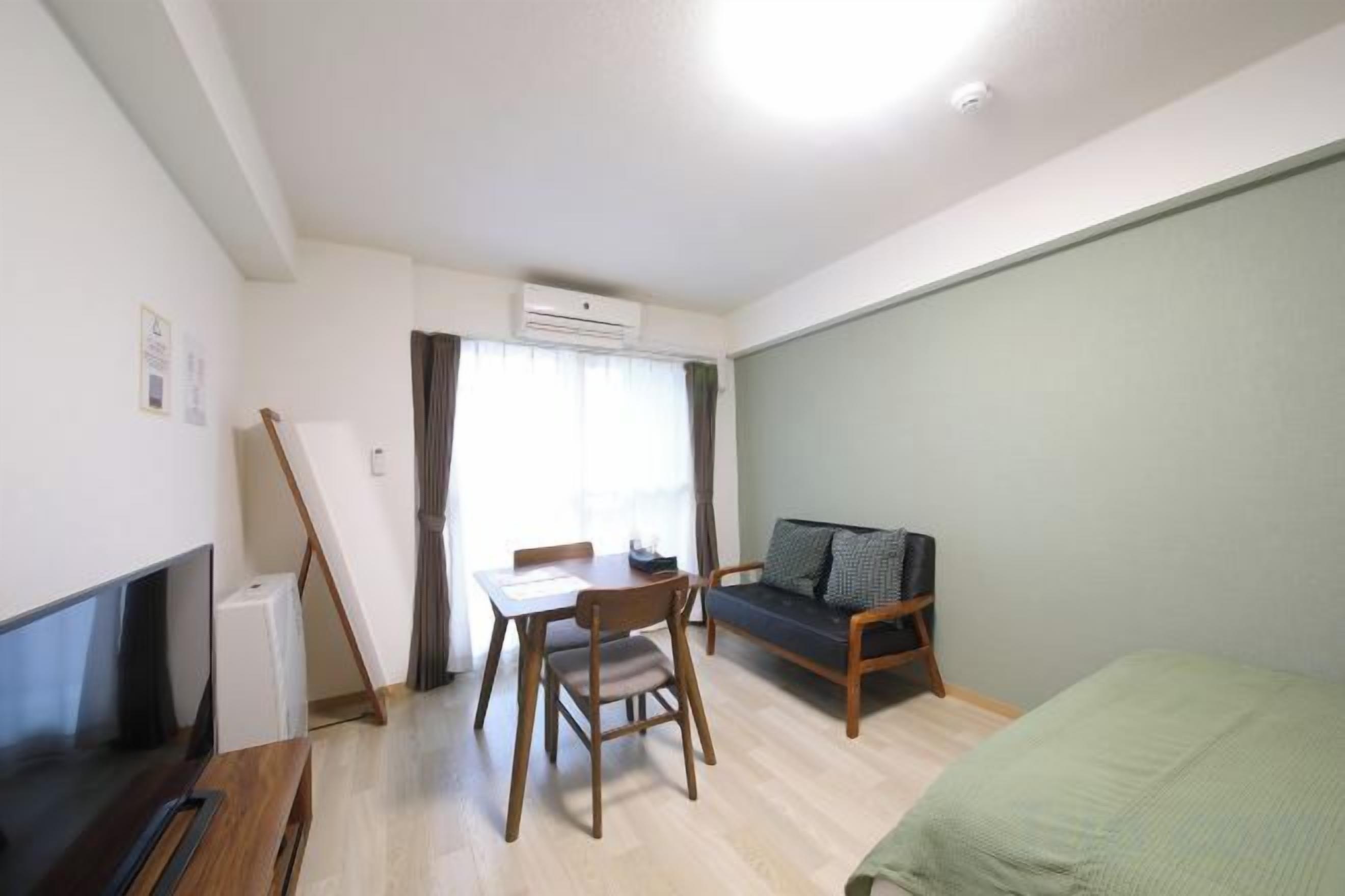 A compact living space with a television, a dining table, and a sofa.