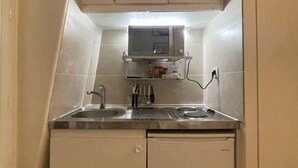 A compact kitchen with a microwave, a sink, and a dishwasher. - Charming Studio in the 7th District of Paris (Paris)