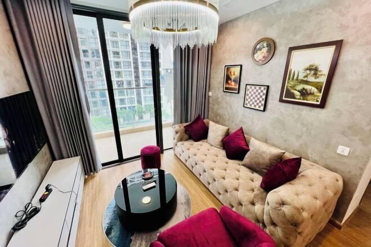 Uma sala de estar moderna com um sofá, uma mesa de centro redonda e um candelabro.