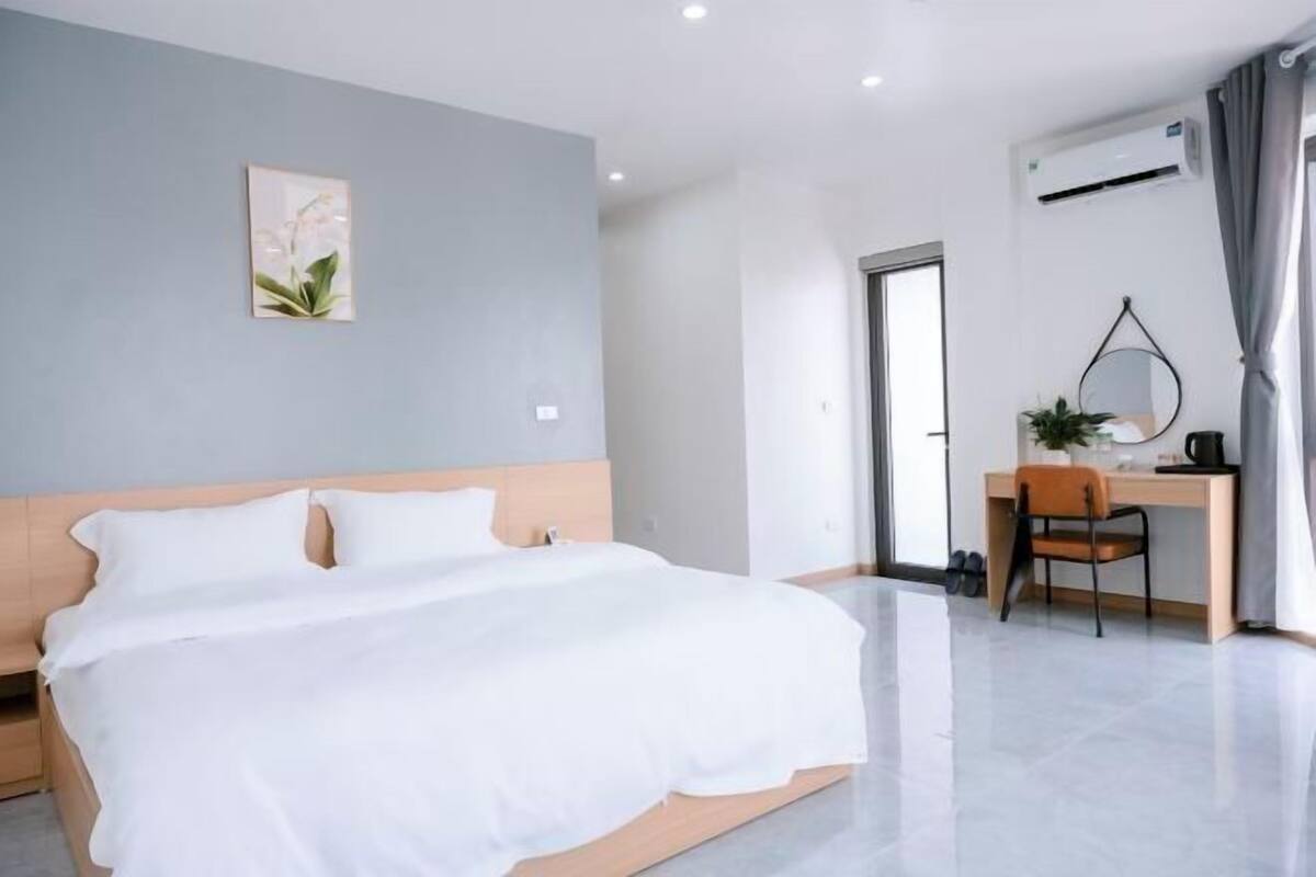 Une chambre d’hôtel moderne, équipée d’un lit, d’un bureau et d’une chaise.