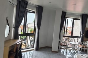 A room with a balcony, a dining table, and chairs. - NGHI THUONG HOTEL (Vo Cuong)