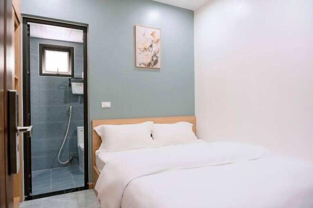 Une chambre avec un lit, une douche et un tableau accroché au mur.