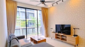 Un salon moderne avec un canapé, un téléviseur et un balcon agrémenté de rideaux.