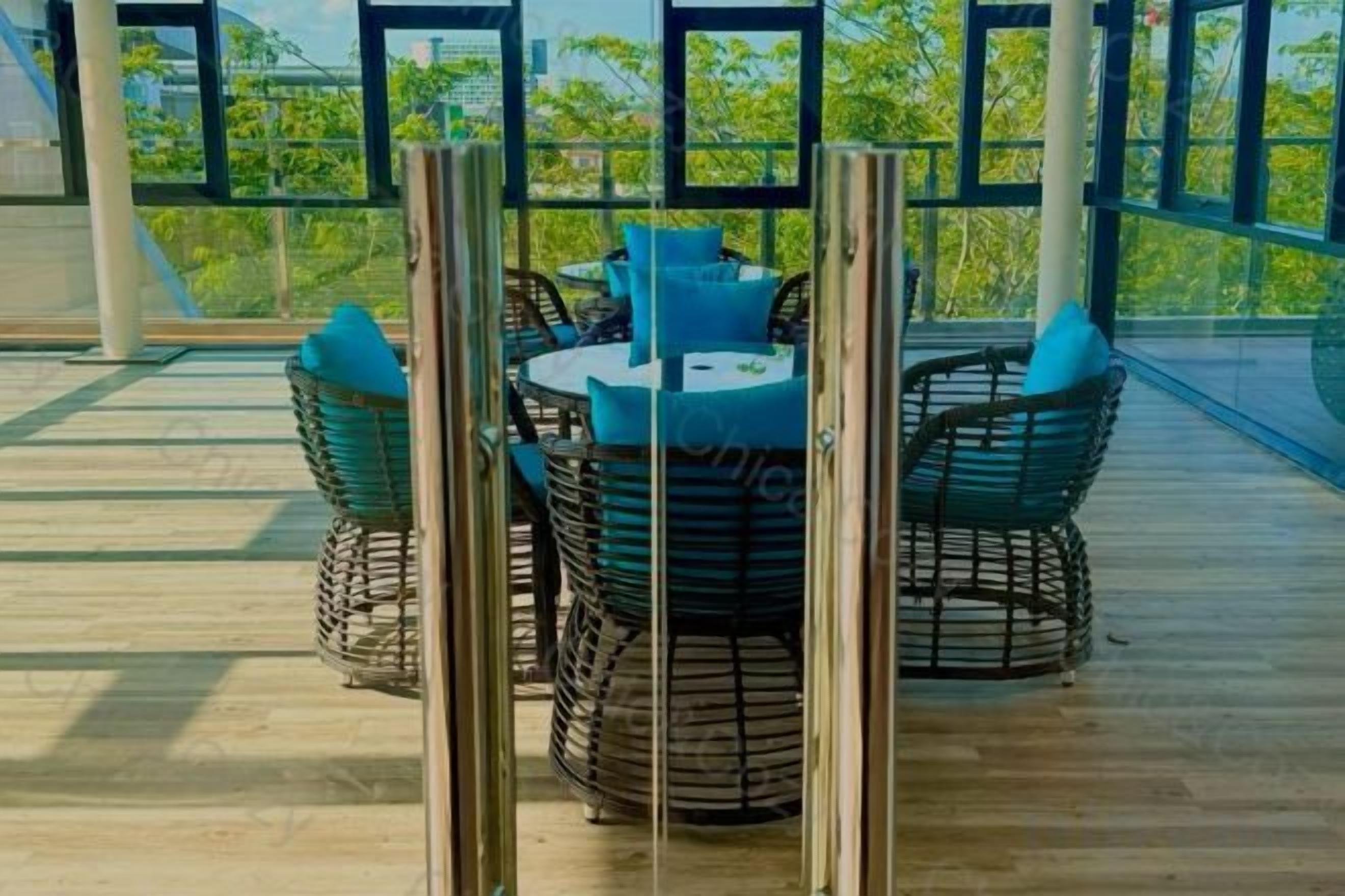 A round table with chairs and a tablecloth, surrounded by a railing.