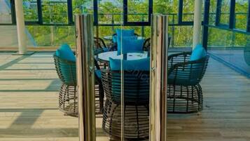 A round table with chairs and a tablecloth, surrounded by a railing.