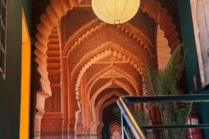 A staircase with ornate arches and a hanging light fixture. - BG Travelers Home (Kuala Lumpur)
