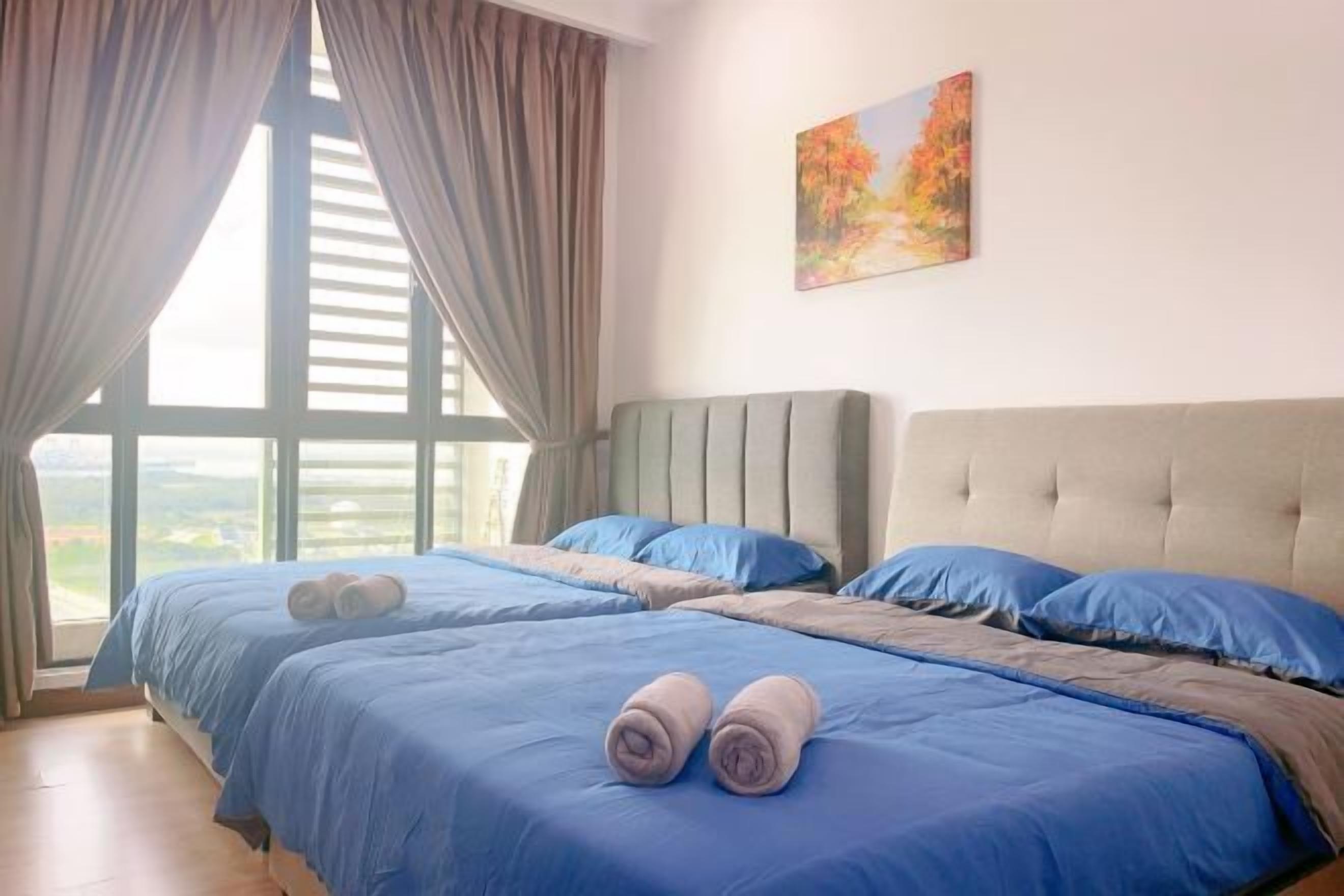 Habitación de hotel con dos camas, un ventanal con cortinas y un cuadro en la pared.