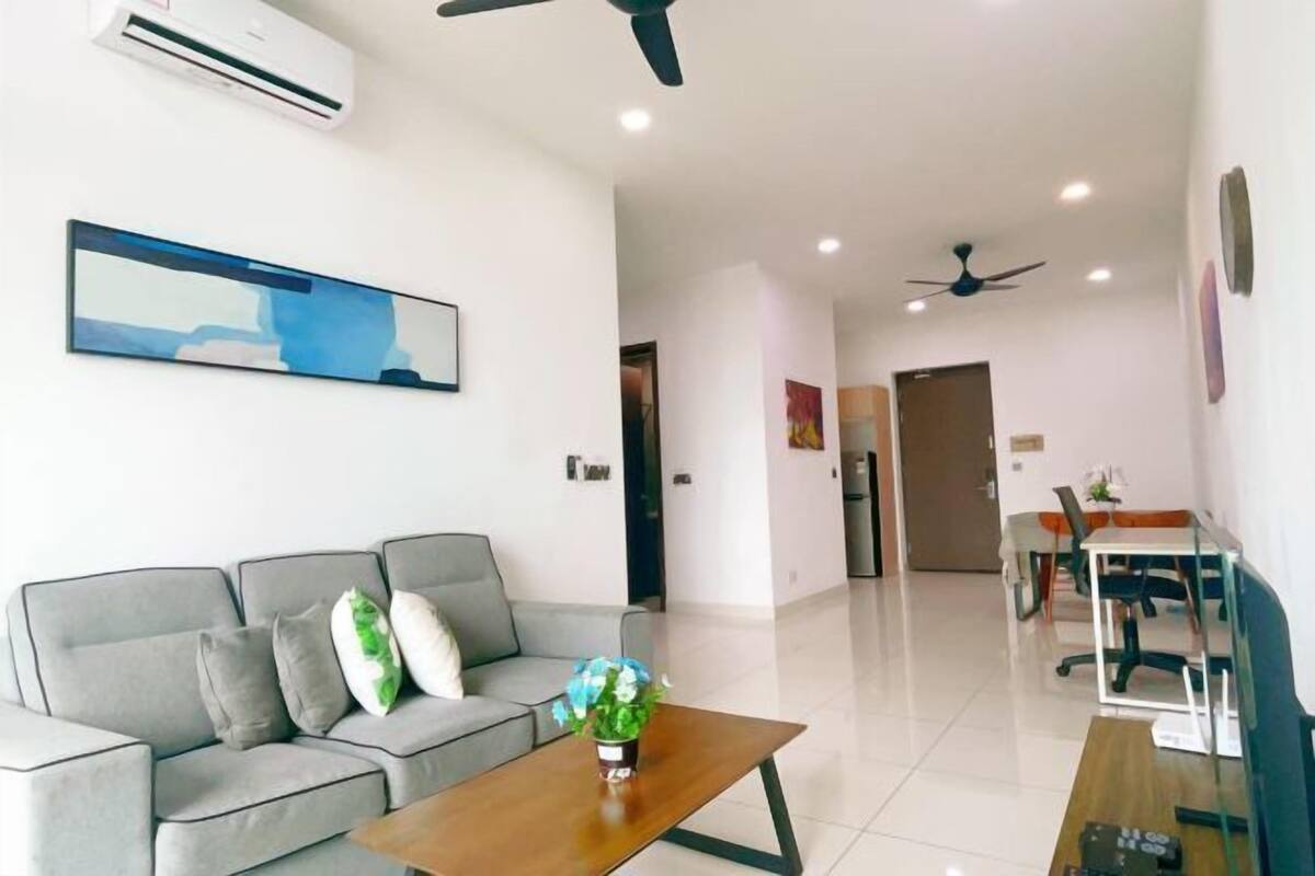 A modern living room with a grey sofa, a wooden coffee table, and a painting on the wall.