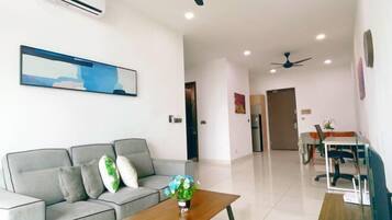 A modern living room with a grey sofa, a wooden coffee table, and a painting on the wall.