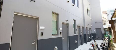 Un edificio moderno con varias puertas y ventanas, y bicicletas estacionadas afuera.