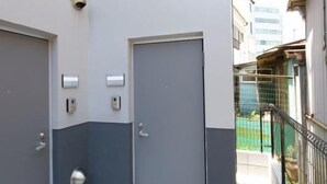 A building with two doors, each with a security camera above and a keypad lock. - Nishi-Shinjuku-Villa (Tokyo)