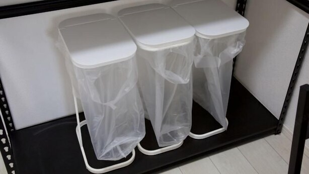 A black metal shelf with three white trash bins with transparent bags. - Nishi-Shinjuku-Villa (Tokyo)