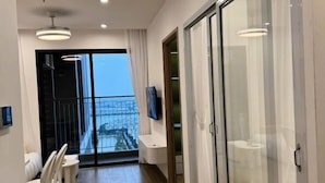 Une chambre d’hôtel moderne dotée d’un balcon, d’une télévision et d’une porte-fenêtre coulissante.