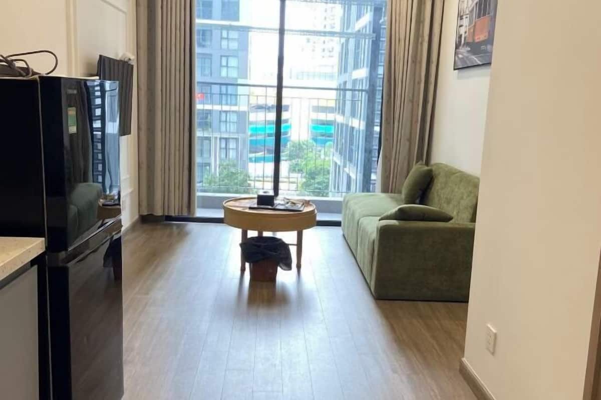 A modern living room with a sofa, a small round table, and a TV.