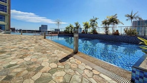 A rooftop pool with stone flooring and palm trees. - The Loft Hostel by Evernent (Miri)