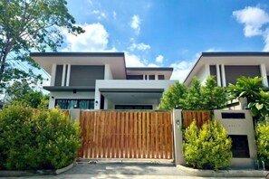 A modern two-story house with a gated entrance, surrounded by greenery. - Bestest Pool Villa (Krabi)