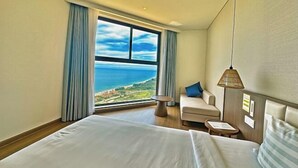 A hotel room with a large window, a bed, a sofa, and a small table. - Mandala Heaven Dreamscape Hotel & Resort (Phan Thiet)