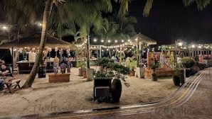A beachside restaurant with outdoor seating, palm trees, and string lights. - Amberside, Country Garden Danga Bay Homestay by Welcome Home (Johor Bahru)